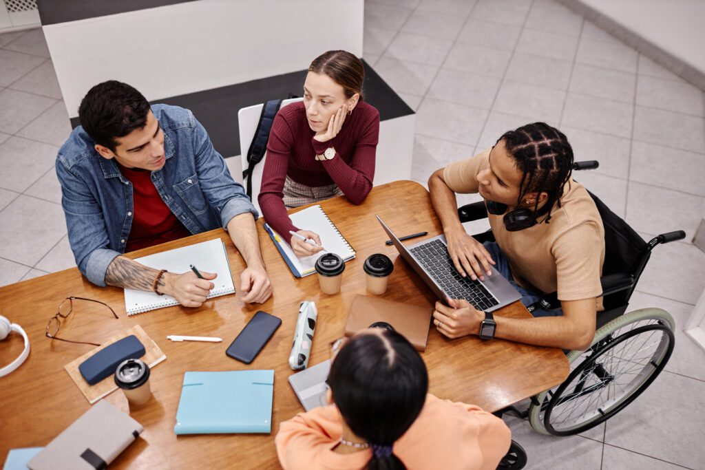 Diverse group of young people studying together in college library